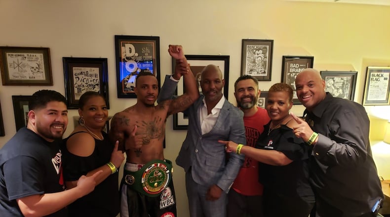 Trotwood native Chris Pearson has his arm raised by boxing great Bernard Hopkins after Pearson beat Yamaguchi Falcao for the WBO Latino Middleweight championship in Las Vegas. Pictured from left, co-trainer Edgar Jasso, Pearson s aunt Deborah Butler from Dayton, Chris Pearson, Bernard Hopkins, trainer Manny Robles, Chris’ aunt Alandis Powell from Dayton and Chris’ dad Milton Pearson. CONTRIBUTED