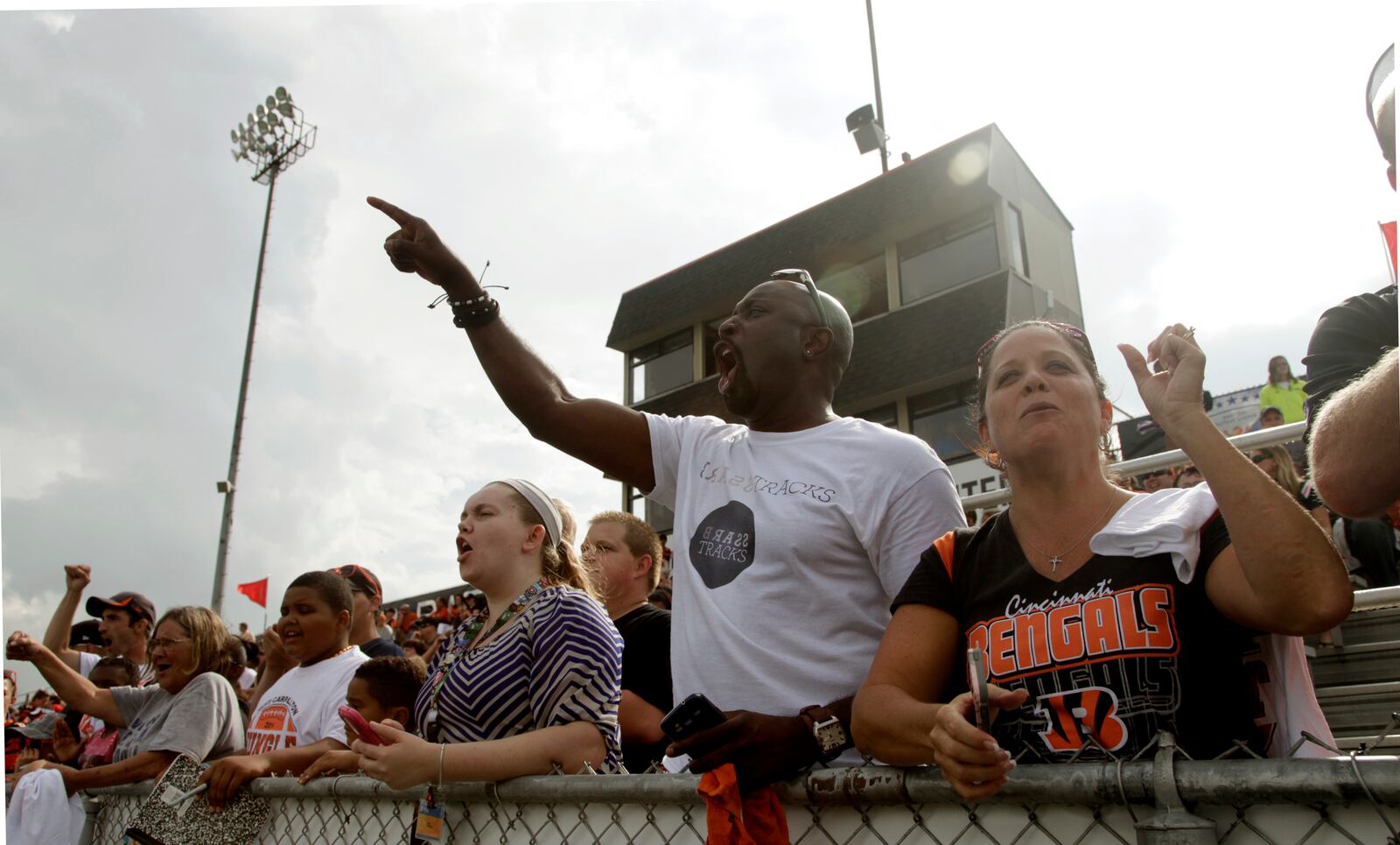 Thousands of Cincinnati Bengals fans, including Jevon Kennedy of Washington Twp. and Kendra Godown of Dayton (right), cheered for the Bengals as they practiced at West Carrollton High School in 2014. LISA POWELL/ STAFF PHOTO