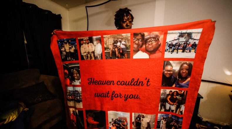 Ira Butler holds-up a blanket of remembrance of her late fiance, Willie Edwards. JIM NOELKER/STAFF