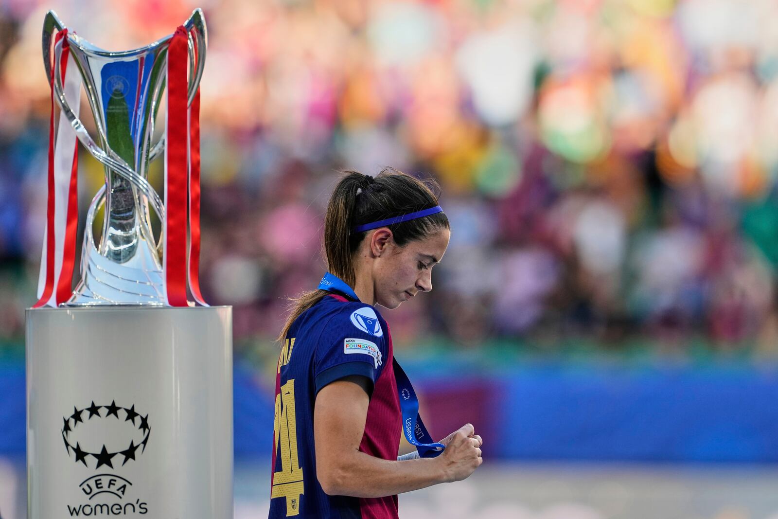 Barcelona's Aitana Bonmati walks past the winner trophy during the podium ceremony after Arsenal won the women's Champions League final soccer match between Arsenal and FC Barcelona at the Jose Alvalade stadium in Lisbon, Saturday, May 24, 2025. (AP Photo/Armando Franca)