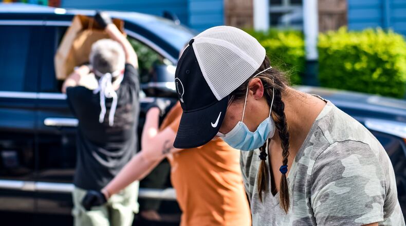 Amanda Ellis wears a mask and gloves as she prepares orders at Cozy’s restaurant Tuesday, April 28, 2020 on Cincinnati Dayton Road in Liberty Township. Cozy’s is trying something different on Tuesdays and Thursdays and offering a drive-up service that will vary by week. Tuesday’s offering was a grill out theme with burgers, hotdogs and more available. They also had margaritas to-go for sale. Cozy’s offers carry out food on other days of the week. NICK GRAHAM / STAFF