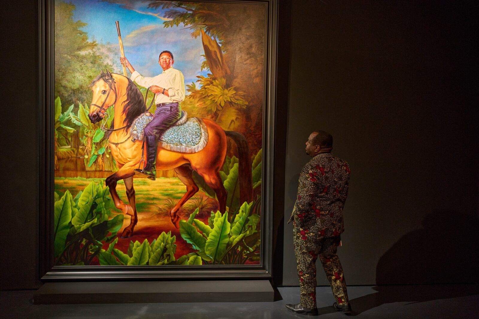 A visitor looks at a portrait of Hery Rajaonarimampianina, former president of Madagascar, during the opening of American painter Kehinde Wiley's exhibition A Maze of Power in Mohammed VI Museum of Modern and Contemporary Art, in Rabat, Tuesday, April 15, 2025. (AP Photo/Mosa'ab Elshamy)