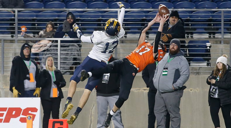 Versailles High School sophomore Michael Osborne catches a touchdown pass over Kirtland's Will Sayle during the Division V state championship game on Saturday night at Tom Benson Hall of Fame Stadium in Canton. Versailles won the game, 20-16. Michael Cooper/CONTRIBUTED