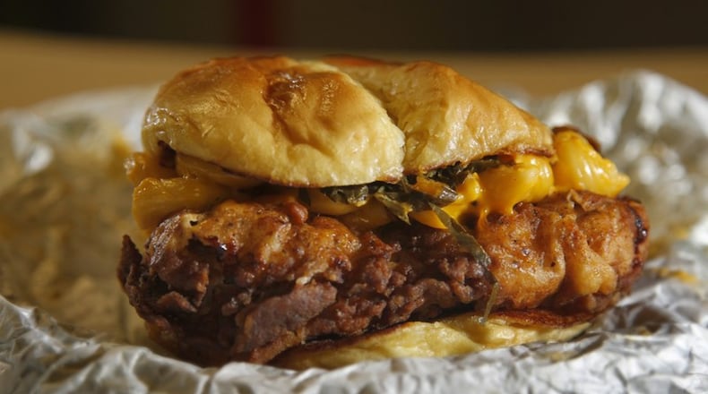 The Medusa chicken sandwich topped with mac and cheese, pickled onions and collard greens available at The Chicken Spot. LISA POWELL/STAFF