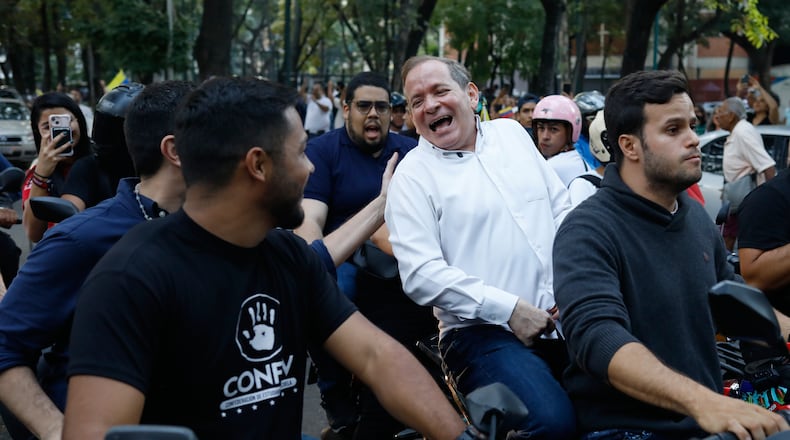 Opposition leader Juan Pablo Guanipa rides on the back of a motorcycle after his release from prison in Caracas, Venezuela, Sunday, Feb. 8, 2026.(AP Photo/Cristian Hernandez)