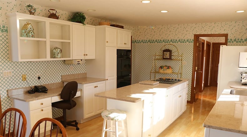 Recently updated with rounded-edge quartz counters, the kitchen features abundant cabinets and a long center island with a smooth-surface cooktop. The long counter on the outside wall incorporates a refrigerator, dishwasher, trash compactor and a double sink centered under casement windows.