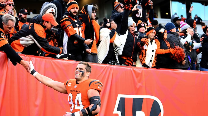 FILE - Cincinnati Bengals defensive end Sam Hubbard (94) high-fives fans after the team's NFL football game against the Pittsburgh Steelers on Nov. 28, 2021, in Cincinnati. Hubbard grew up in Cincinnati and followed the “Bungles” as they stumbled and bumbled throughout much of his youth. His first three years as a Bengals were pretty much the same. “It’s just really cool how many people have thanked me for the relief they’ve felt, the time that they had watching the games, the great memories they’ve had from these wins this year,” Hubbard said. (AP Photo/Emilee Chinn, File)