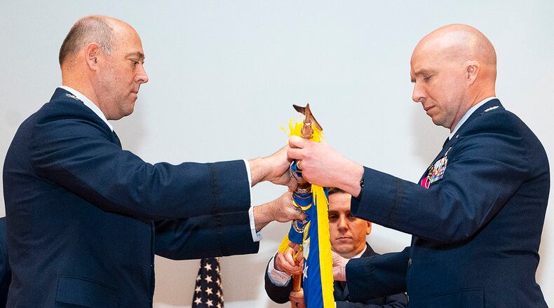 Col. Patrick Miller (left), 88th Air Base Wing and installation commander, and Col. Ivan Herwick, 88th Communications Group commander, furl the 88 CG guidon, marking the unit’s inactivation during a ceremony April 29 at Wright-Patterson Air Force Base. The group’s two squadrons were redesignated under other 88 ABW agencies as part of a reorganization. U.S. AIR FORCE PHOTO/R.J. ORIEZ