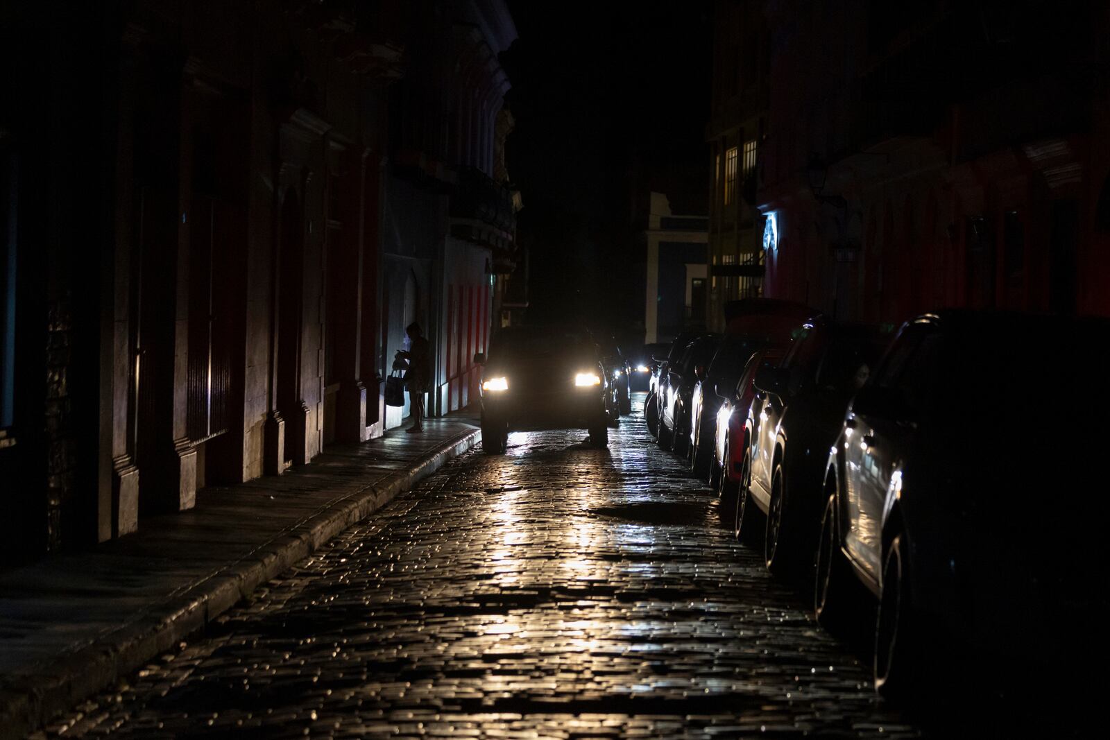 Headlights illuminate cobblestone streets in Old San Juan, Puerto Rico, during an island-wide blackout, Wednesday, April 16, 2025. (AP Photo/Alejandro Granadillo)