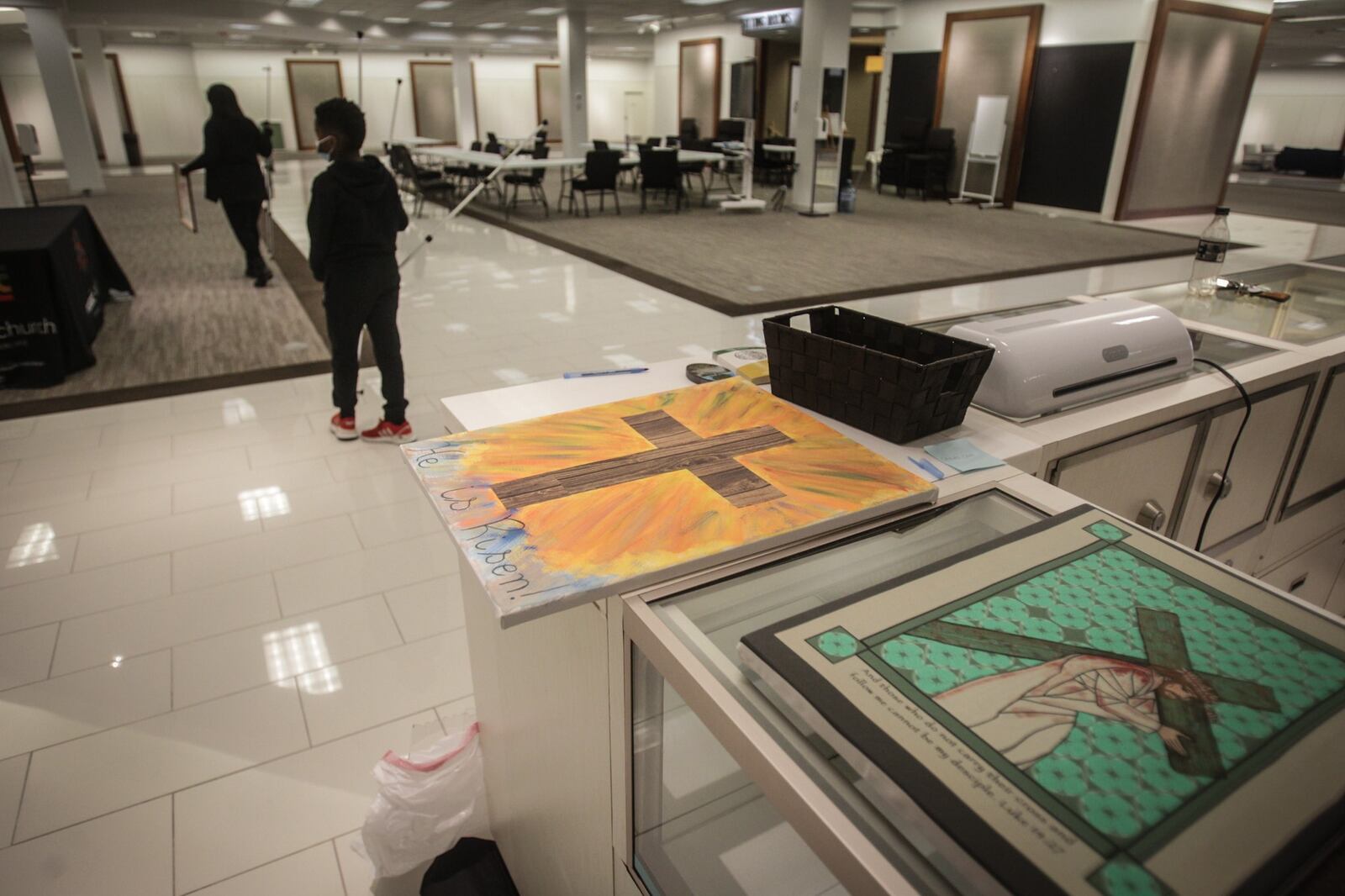 Mosaic Church online worship director, D.J. Shorter sets-up the stations of the cross in the old Elder Beerman Store at  the Fairfield Commons Mall Thursday morning. The church moved into the closed retail space because of the size of the space for COVID-19 distancing. JIM NOELKER/STAFF