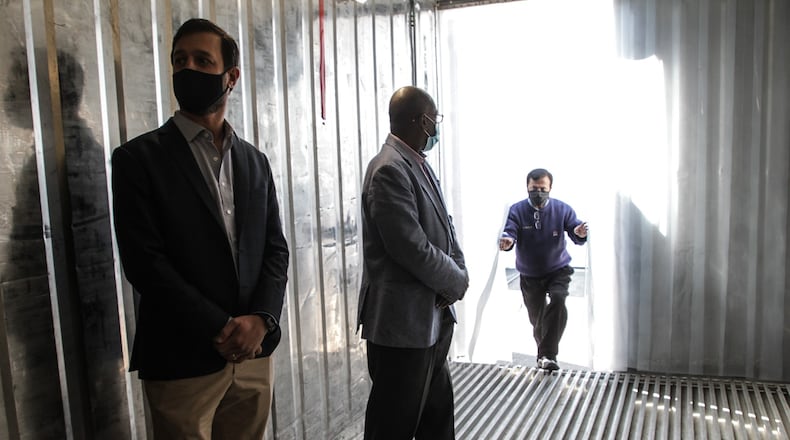 From left, Etai Tinma, Brent Boyd and Neil Chaudhry check out the solar powered refrigerator in Miamisburg Monday April 19, 2021.