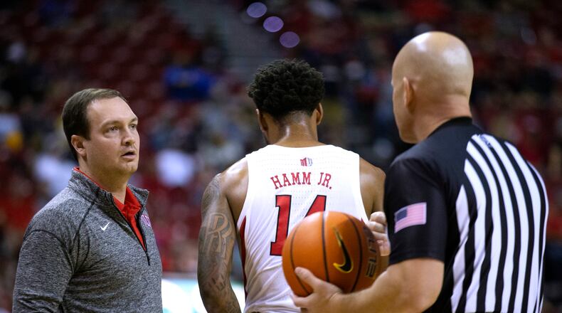 UNLV coach Kevin Kruger talks with an official, who had called a double foul on UNLV forward Royce Hamm Jr. during the second half of the team's NCAA college basketball game against UCLA on Saturday, Nov. 27, 2021, in Las Vegas. (Ellen Schmidt/Las Vegas Review-Journal via AP)