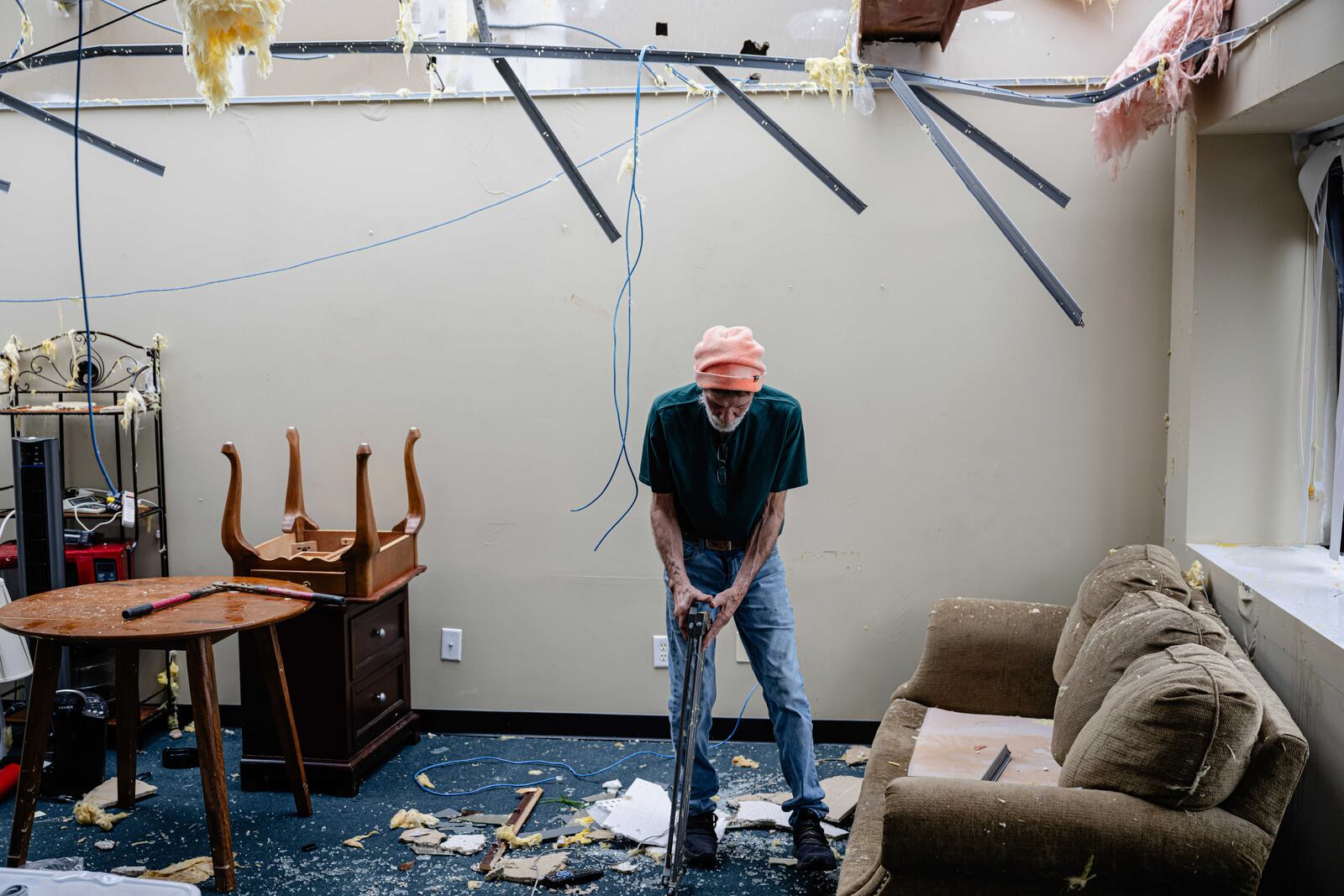 Mike Davis moves debris from a damaged business in the Triad Building, a business plaza, after severe weather passed through Thursday, April 3, 2025, in Louisville, Ky. (AP Photo/Jon Cherry)