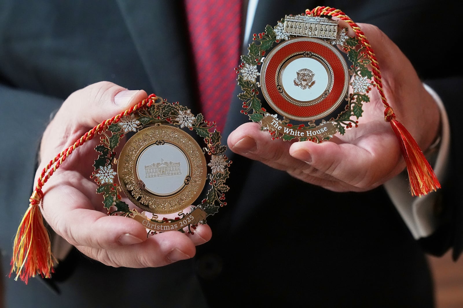 White House Historical Association President Stewart McLaurin poses with the 2025 White House Christmas ornament, seen at front and back, Thursday, April 10, 2025, at the association in Washington. (AP Photo/Jacquelyn Martin)