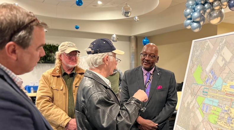 Dayton International Airport Director of Aviation Gil Turner, right, speaks with community members about the airport's 10-year master plan during an open house Wednesday. AIMEE HANCOCK/STAFF