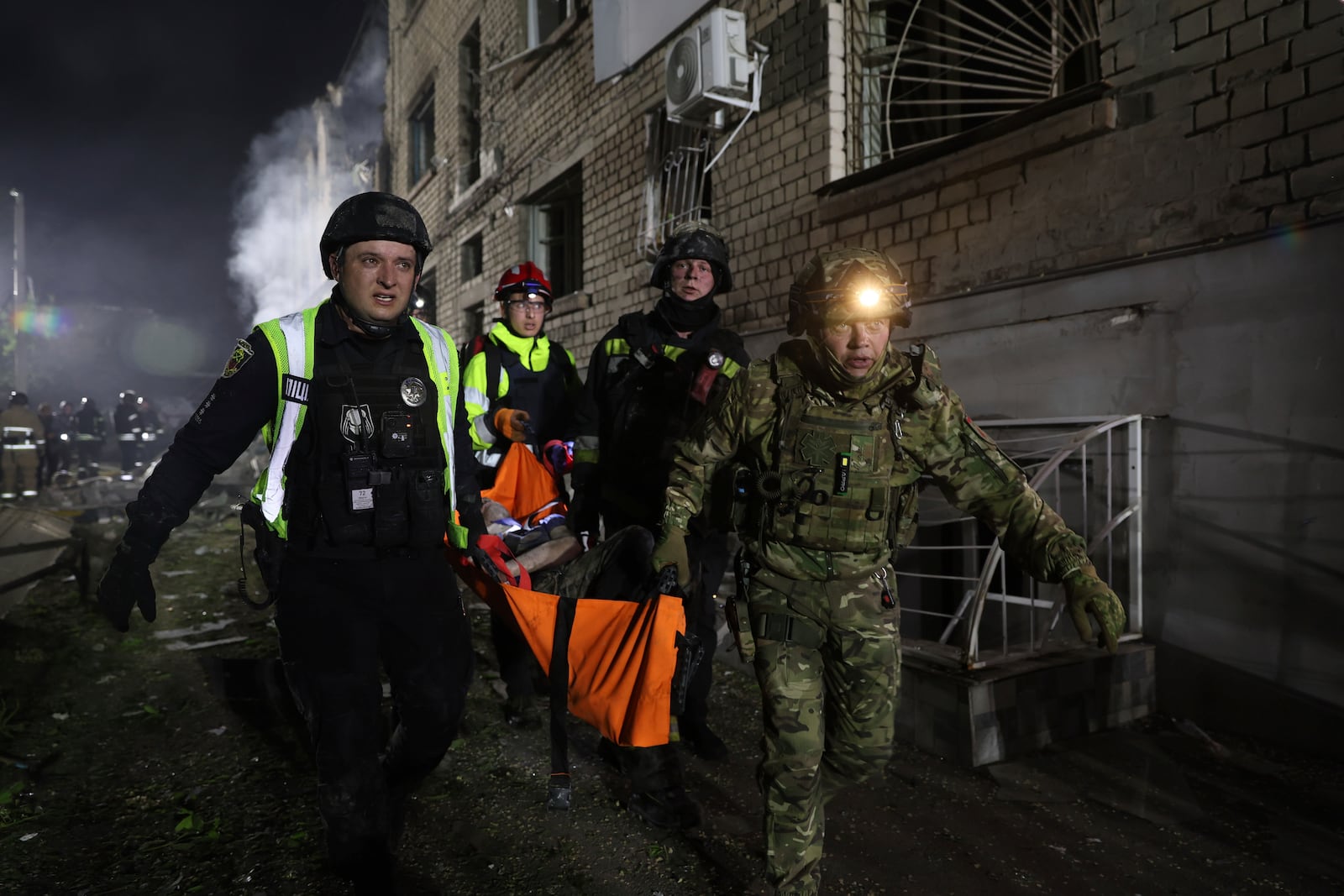Police carry an injured man on a stretcher after a Russian strike on residential neighborhood in Zaporizhzhia, Ukraine, Thursday, May 1, 2025. (AP Photo/Kateryna Klochko)
