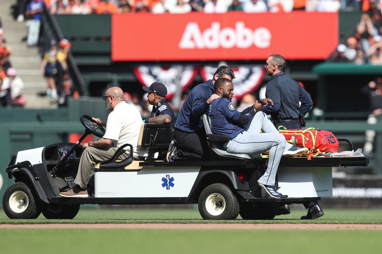 Seattle Mariners right fielder Victor Robles, front right, is carted off the field during the ninth inning of a baseball game against the San Francisco Giants in San Francisco, Sunday, April 6, 2025. (AP Photo/Kavin Mistry)