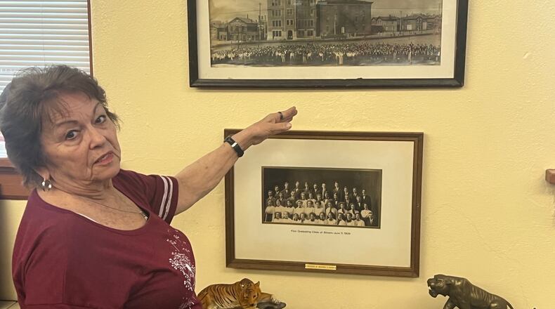 Judy Kennard points out photos of the school and the first graduating class (from 1909) that are displayed in the Alumni Room at Stivers. Tom Archdeacon/Contributed