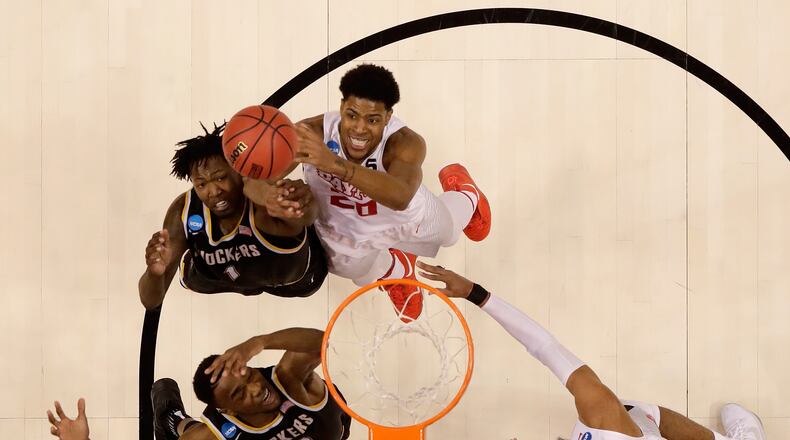 Xeyrius Williams (#20) of the Dayton Flyers battles Wichita State's Zach Brown for a rebound during the first round of the NCAA Baketball Tournament at Bankers Life Fieldhouse on March 17, in Indianapolis, Indiana.