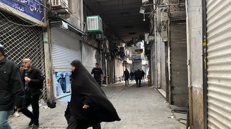 People walk as shops are closed during protests in Tehran's centuries-old main bazaar, Iran, Tuesday, Jan. 6, 2026. (AP Photo/Vahid Salemi)