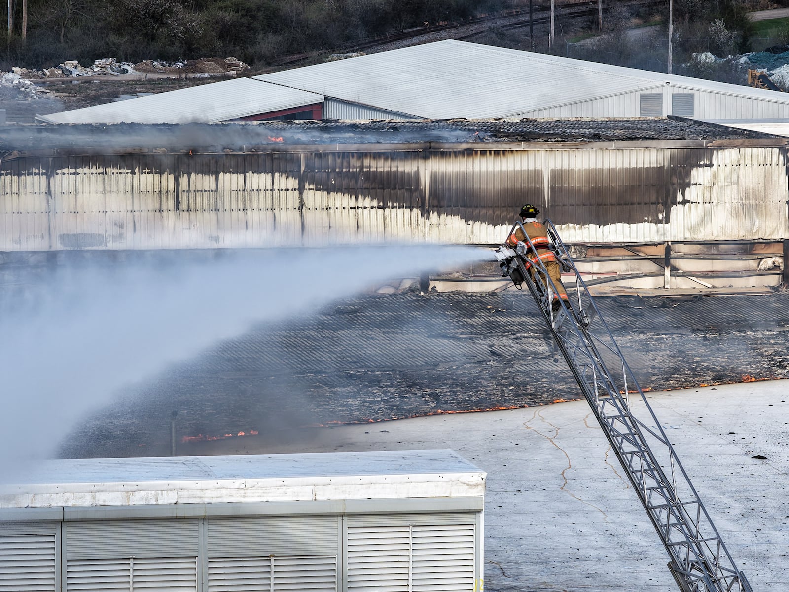 Morning crews work to extinguish remaining flames at the Fuyao Glass America plant in Moraine following a large fire. NICK GRAHAM / STAFF