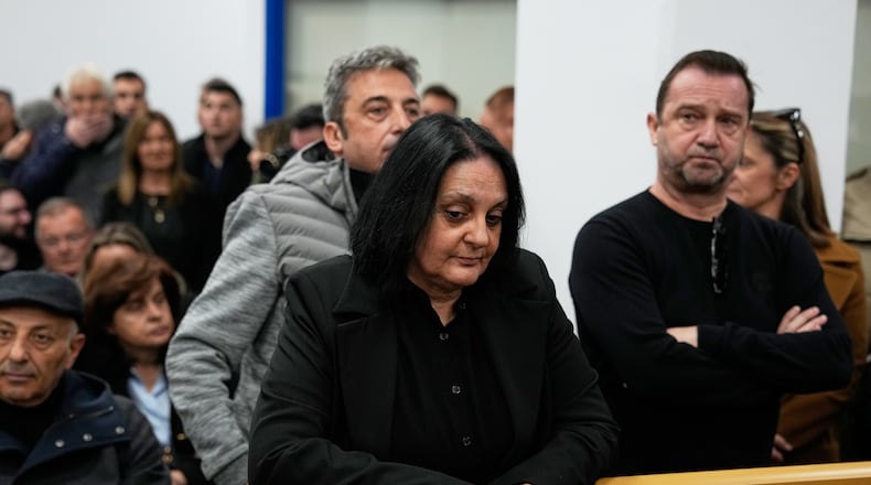 Relatives of victims of the Tempi train crash wait for the trial at the court in Larissa, Greece, Monday, March 23, 2026. (AP Photo/Thanassis Stavrakis)