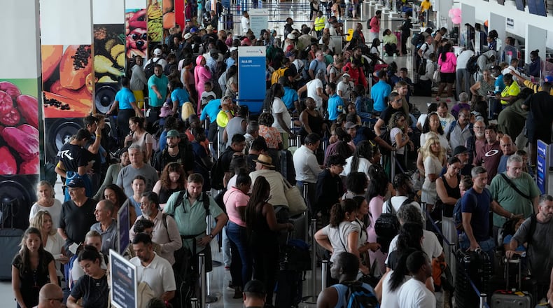 Passengers check in at the Norman Manley International Airport in Kingston, Jamaica, Saturday, Nov. 1, 2025, in the aftermath of Hurricane Melissa. (AP Photo/Matias Delacroix)