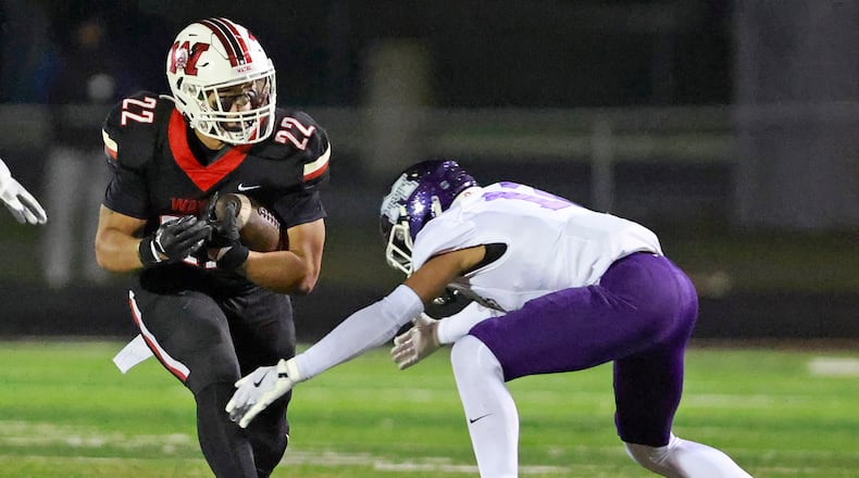 Wayne's Isaiah Thompson is tackled by Middletown's Elijah Harris as he carries the ball during Friday's playoff game. BILL LACKEY/STAFF