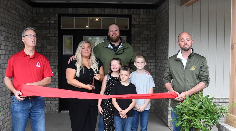 Operation FINALLY HOME executive director Rusty Carroll (left) along with Josh Dungan of JM Dungan Custom Homes (far right) welcome the Zurn family (L-R Brittany, Aaron, daughter Tatum, Sons Porter and Keegan) Through community donations, the Zurn family also received new furniture for their home. CONTRIBUTED