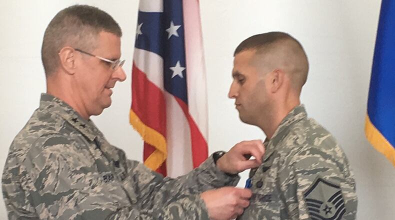 Ohio Adjutant General, Maj. Gen. Mark Bartman, pins the Ohio Cross on Master Sgt. Dallas Root of the 178th Wing in Springfield Saturday. This is Root’s second time earning the award for putting his life at risk to save another’s.