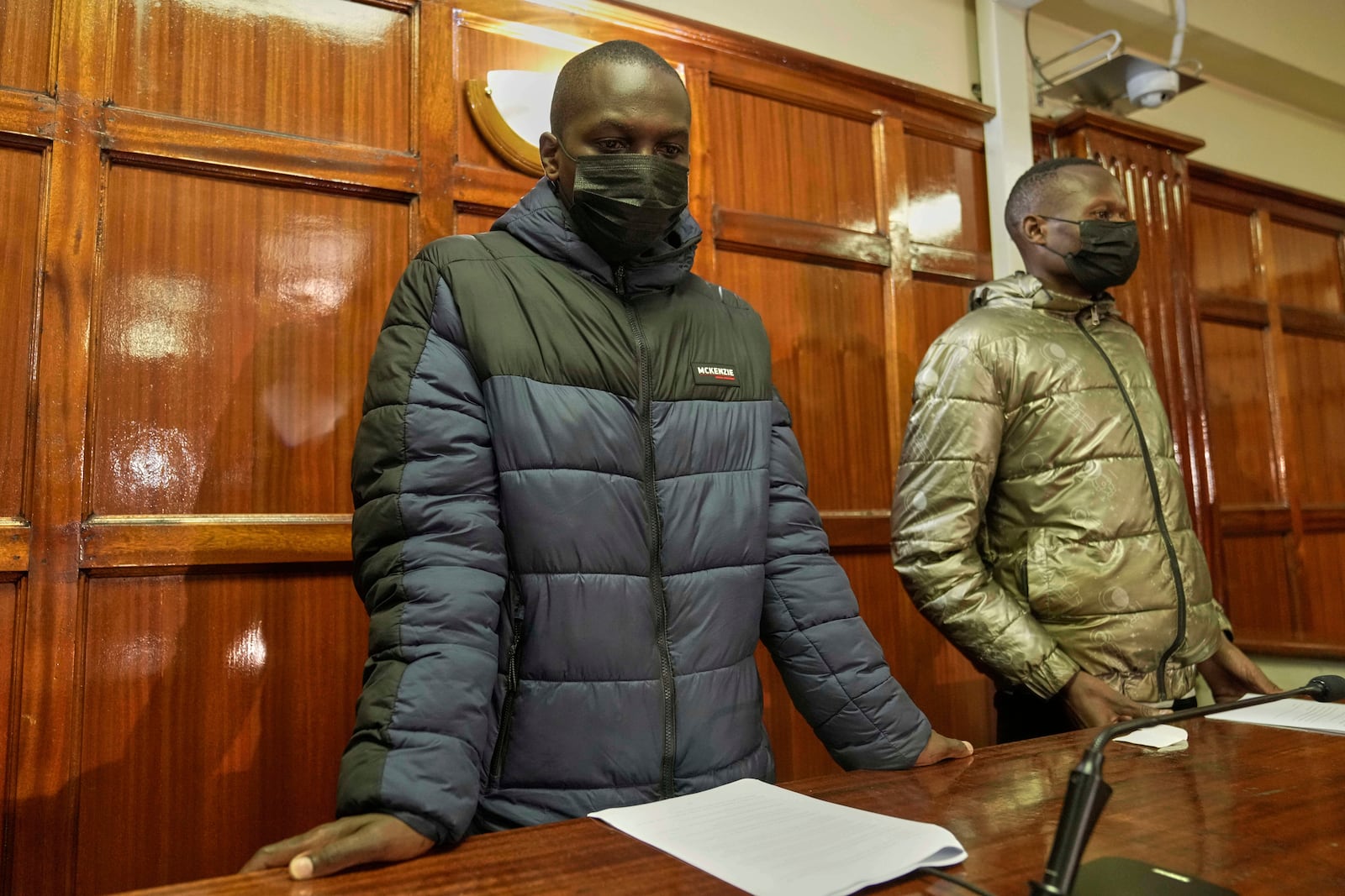 Kenya police officers Duncan Kiprono, left, and Baraza Masinde, right, accused of assaulting and shooting hawker Boniface Mwangi Kariuki during a protest, appear at the Milimani Law Courts in Nairobi, Kenya Thursday, June 19, 2025. (AP Photo/Brian Inganga)
