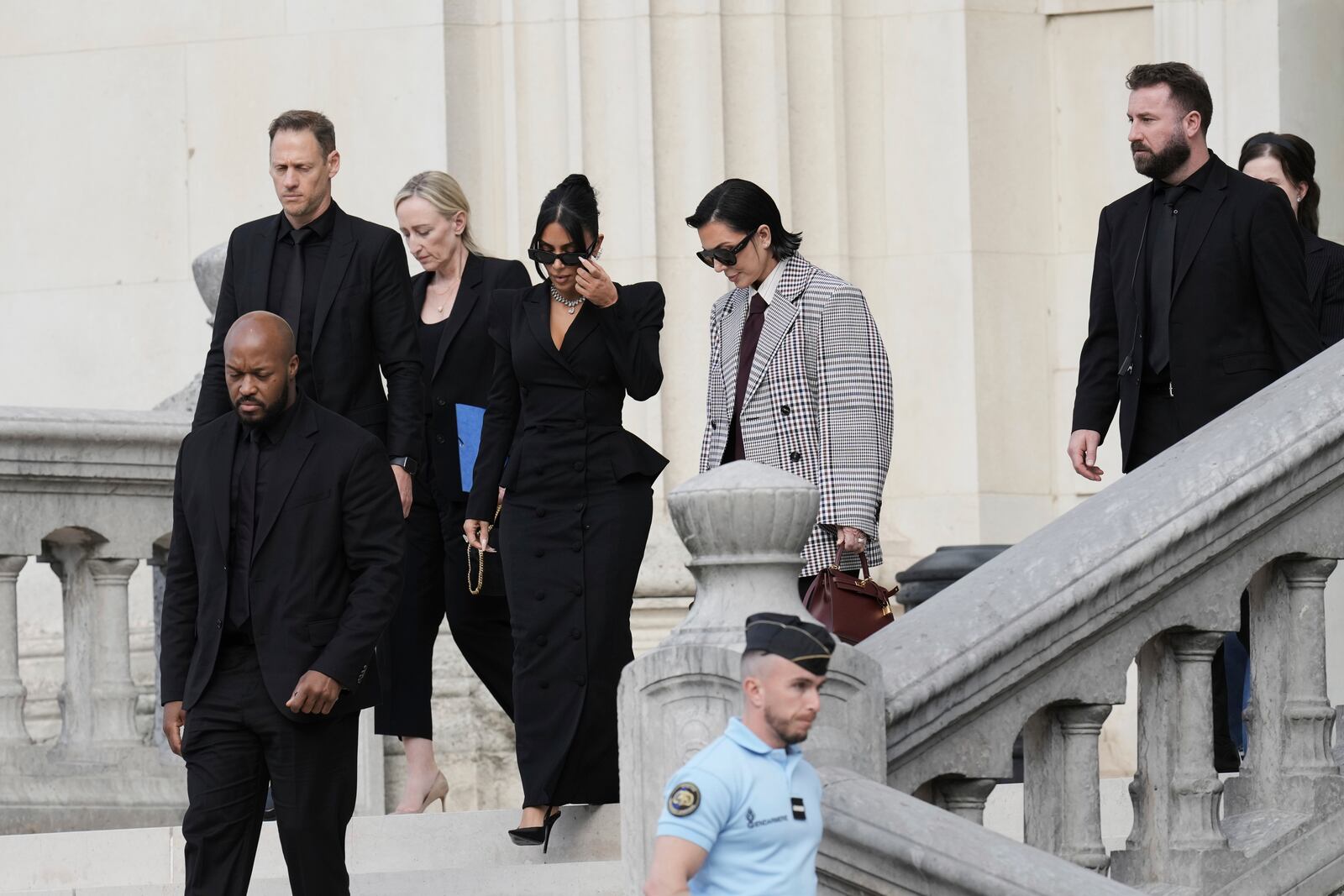 Kim Kardashian, center left, accompanied by her mother Kris Jenner, center right, leaves the justice palace after testifying, regarding a robbery of millions of dollars in jewels from her Paris hotel room in 2016, in Paris, Tuesday, May 13, 2025. (AP Photo/Aurelien Morissard)