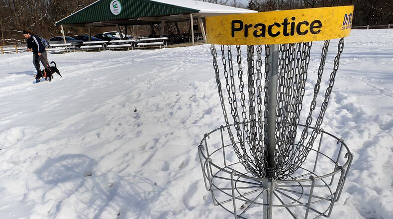 A visitor walks his dog near the disc golf course at Caesar Ford Park in Greene County on Tuesday Jan. 24, 2023. More Ohioans have stuck with getting outside post-pandemic, per data from state and local park districts. Greene County Parks and Trails is building a $3.2 million Class A campground, at Caesar Ford, with plans to open later this year. MARSHALL GORBY\STAFF