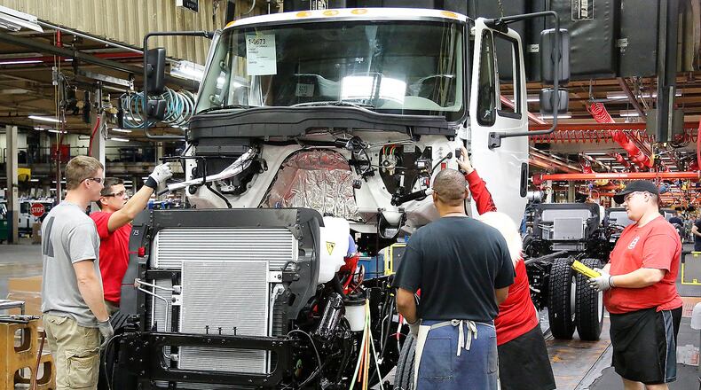 Workers at Navistar assemble a truck cab. Bill Lackey/Staff