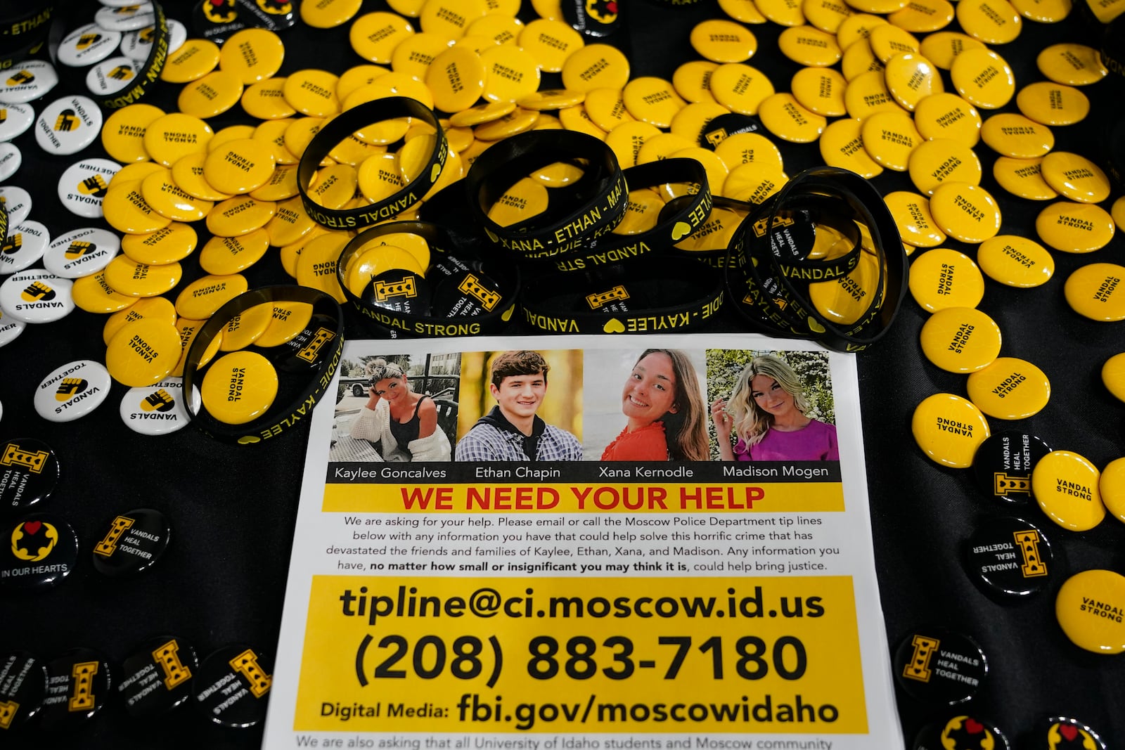 FILE - A flyer seeking information about the killings of four University of Idaho students who were found dead is displayed on a table along with buttons and bracelets, on Nov. 30, 2022, during a vigil in memory of the victims in Moscow, Idaho. (AP Photo/Ted S. Warren, File)