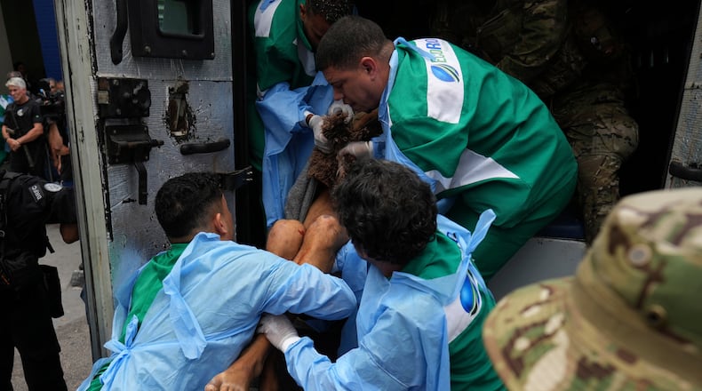 Getulio Vargas Hospital workers remove an injured person from a police truck after he was injured in a police operation against alleged drug traffickers in the Complexo do Alemao favela where the criminal organization "Comando Vermelho" operates in Rio de Janeiro, Tuesday, Oct. 28, 2025. (AP Photo/Silvia Izquierdo)