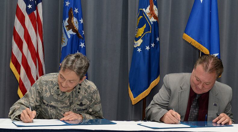 Gen. Ellen M. Pawlikowski, Air Force Materiel Command commander, and Troy Tingey, American Federation of Government Employees Council 214 president, sign a labor agreement during the Master Labor Agreement signing ceremony Aug. 23 at Headquarters Air Force Materiel Command. (U.S. Air Force photo/Michelle Gigante)
