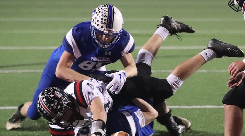 Covington’s Deacon Shields tries to stretch into the end zone as he’s tackled by two Chillicothe Southeastern players near the goal line. BILL LACKEY/STAFF