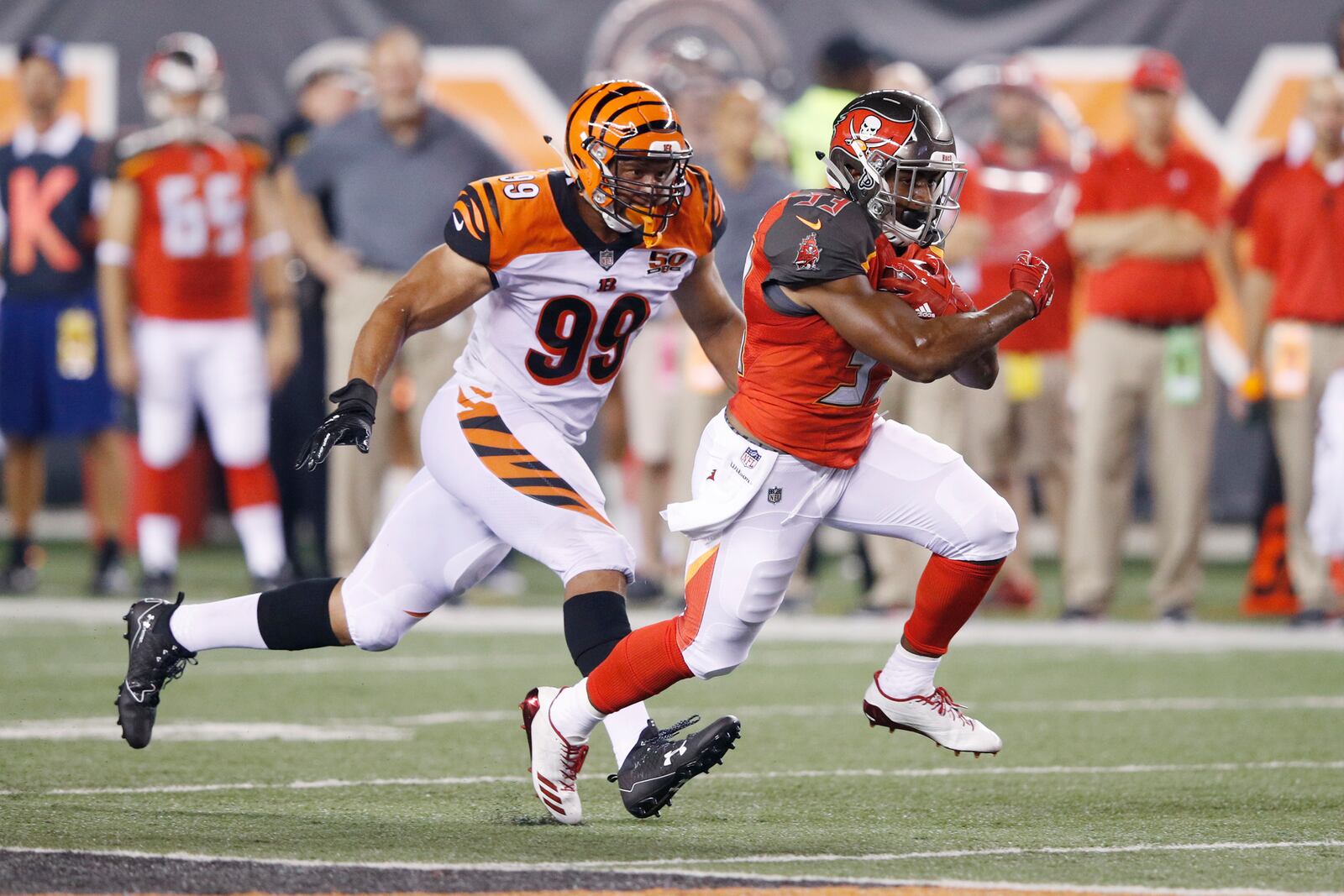 CINCINNATI, OH - AUGUST 11: Jeremy McNichols #33 of the Tampa Bay Buccaneers runs the ball ahead of Jordan Willis #99 of the Cincinnati Bengals in the fourth quarter of a preseason game at Paul Brown Stadium on August 11, 2017 in Cincinnati, Ohio. (Photo by Joe Robbins/Getty Images)