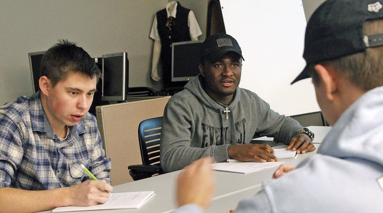 Sinclair Community College Aviation Technology students watch the control panel with Professor Steve Hanshew as student Zeke Swank flies a flight simulator lesson. TY GREENLEES / STAFF