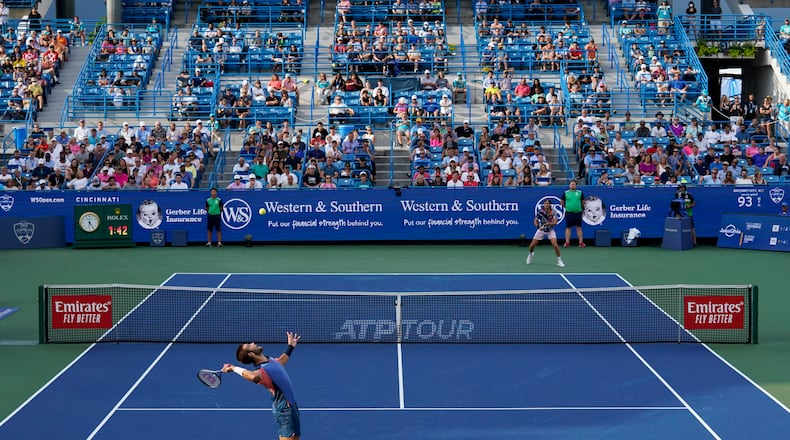Borna Coric, bottom left, of Croatia, serves to Stefanos Tsitsipas, of Greece, during the men's singles final of the Western & Southern Open tennis tournament Sunday, Aug. 21, 2022, in Mason, Ohio. (AP Photo/Jeff Dean)