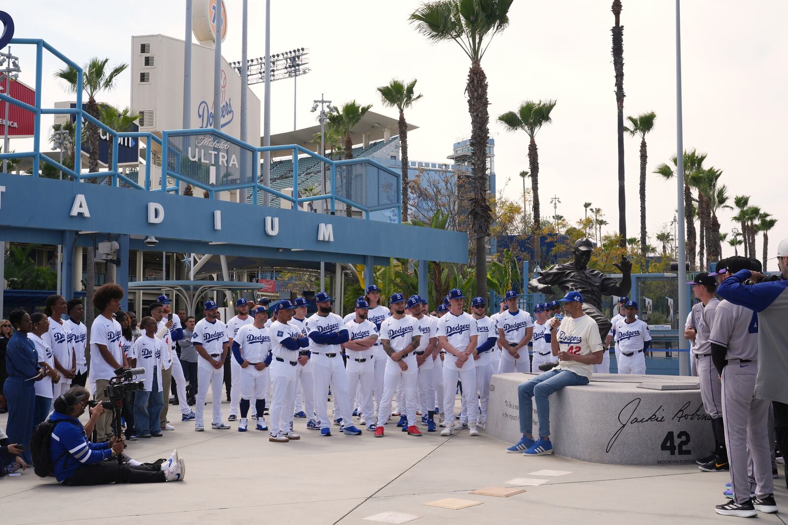 Former NBA basketball player Kareem Abdul-Jabbar speaks to members of the Los Angeles Dodgers and Colorado Rockies to commemorate Jackie Robinson Day before a baseball game at Dodger Stadium Tuesday, April 15, 2025, in Los Angeles. (AP Photo/Damian Dovarganes)