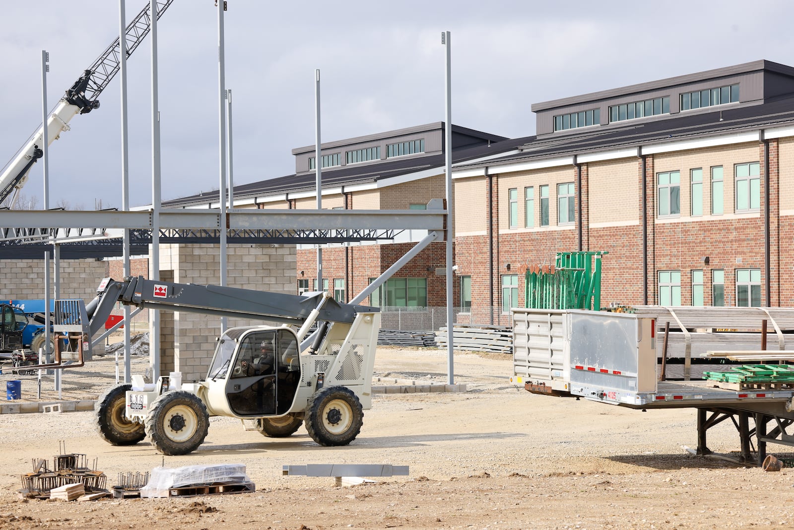 A construction worker drives a telehandler on the site of the future Fairborn Middle School on Thursday, Feb. 19. The school, which is being constructed next to Fairborn High School on Commerce Center Boulevard, is planned to open in the summer of 2027. BRYANT BILLING / STAFF