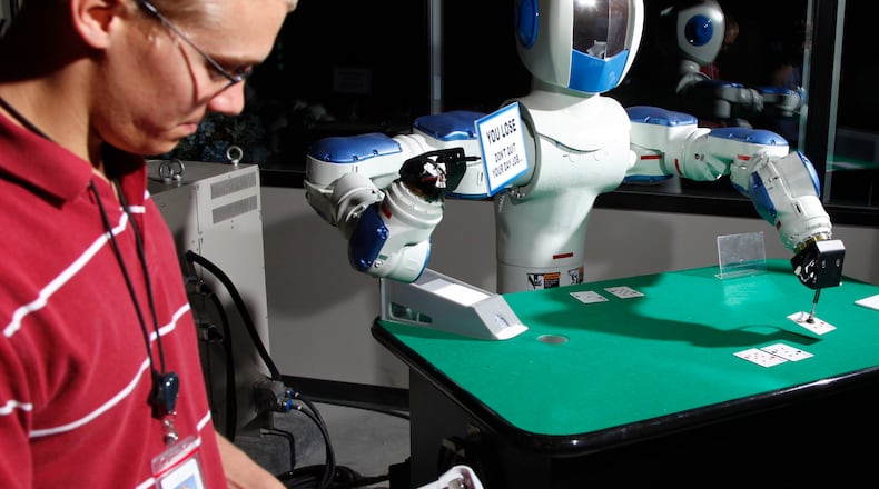 Attracting more foreign-owned companies — such as Yaskawa Motoman in Miamisburg — was a rationale for a vote Friday to fully fund a Canadian company’s plan to move its U.S. headquarters to the Dayton area. In this file photo, Yaskawa Motoman co-op worker Greg Smith checks the programming of a two-armed robot that plays Blackjack in the company’s showroom. TY GREENLESS/STAFF
