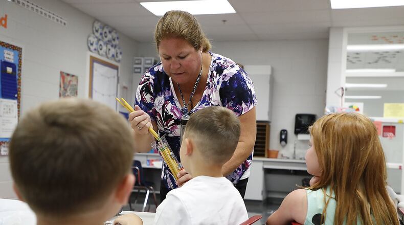 Horace Mann Elementary School teacher Kim Briggs collects school supplies from her first grade students Wednesday during the first day of school. Bill Lackey/Staff