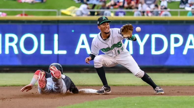 Dayton Dragons shortstop Miguel Hernandez waits for the ball as the Lansing Lugnuts’ Griffin Conine slides back into second base after a pick-off attempt by catcher Jay Schuyler during their game on Thursday night at Fifth Third Field. The Dragons won 7-2. CONTRIBUTED PHOTO BY MICHAEL COOPER