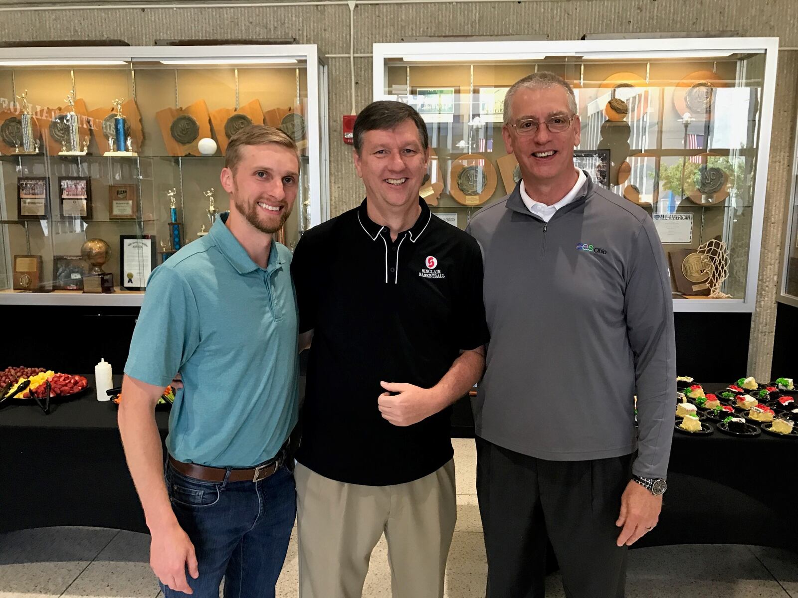 JEFF 2 -- – Sinclair Community College basketball coach and athletics director Jeff Price is flanked by former player Kevin Vest (left), who went on from Sinclair to play at Tusculum University in eastern Tennessee and Kevin’s dad, Mark Vest, who was a Hall of Fame player at Wright State University. Several former Sinclair players, coaches, school administrators, referees and friends of the Tartans' program gathered Friday outside the school's gym to give Price a sendoff. After 21 years at the school, he leaves Monday to become the associate head coach at the University of Central Arkansas, an NCAA Division I school  in Conway, Arkansas. Tom Archdeacon/STAFF