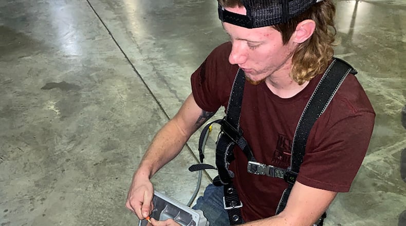 Trevor Hall, an electrical trades apprentice, uses his skills to repair a light fixture at Wright-Patterson Air Force Base. CONTRIBUTED PHOTO