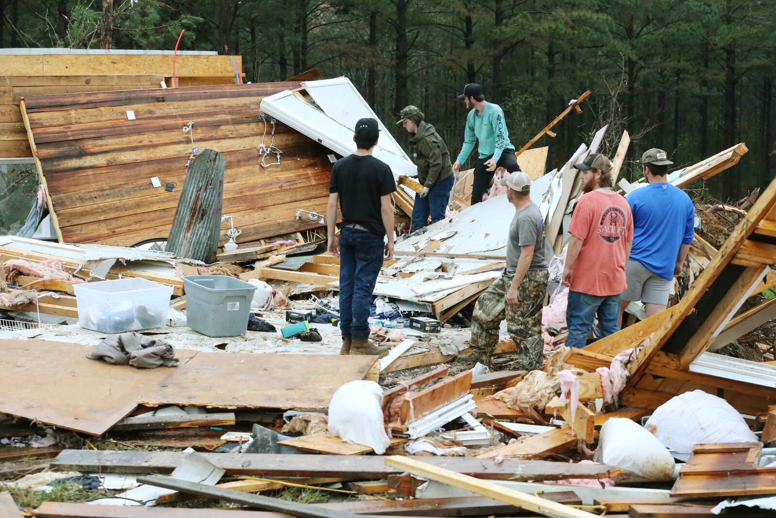 Family and friends begin picking up whats left of a house that was ripped off it's foundation and thrown over 75 feet away along Tippah County Rd. 122 in the Three Forks Community near Walnut Miss., Thursday, April 3, 2025. (Thomas Wells /The Northeast Mississippi Daily Journal via AP)