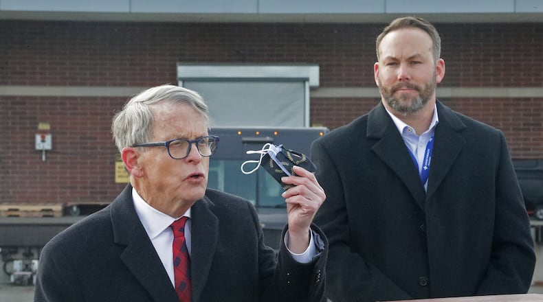 Gov. Mike DeWine reminds residents that they still need to wear a mask Tuesday, Dec. 15, 2020, as Springfield Regional Medical Center President Adam Groshans listens shortly after the first vaccine arrives at the hospital. BILL LACKEY/STAFF